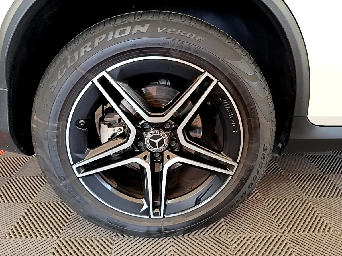 Gros plan sur la roue avant droite noire et argentée AMG du Mercedes GLC Coupé blanc hybride rechargeable.