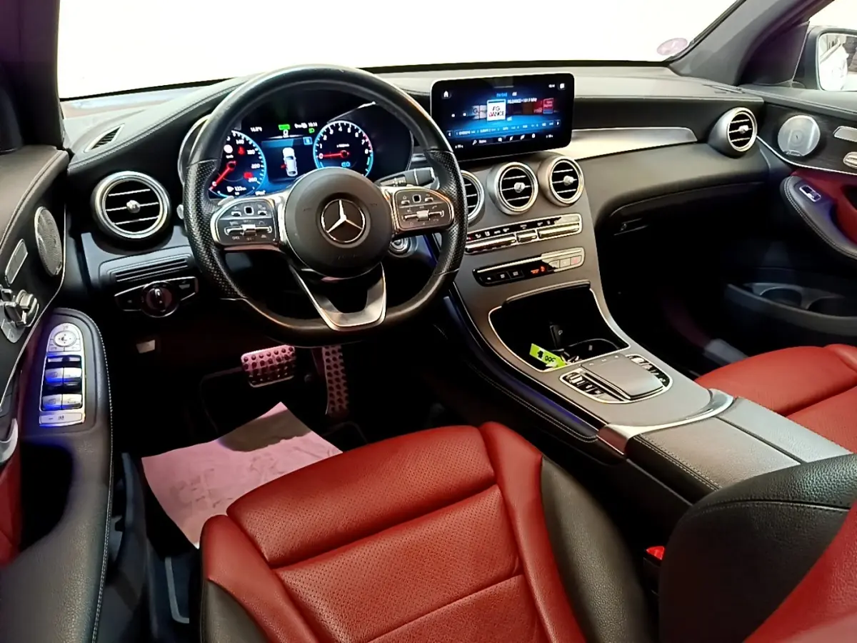 Vue intérieure avant droite du Mercedes GLC 300 e AMG Line avec sièges rouge et tableau de bord numérique.