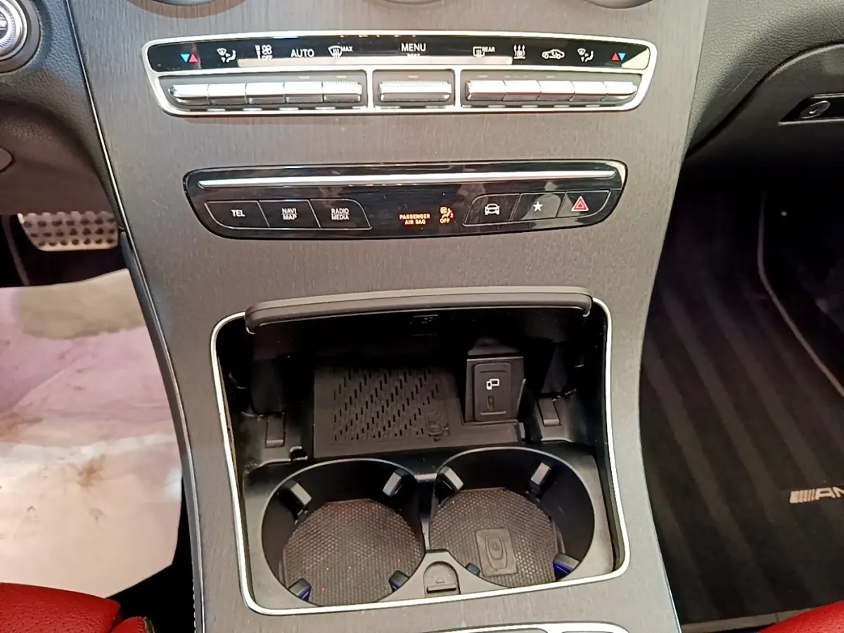 Vue rapprochée de la console centrale du Mercedes GLC 300 e AMG Line 2020, avec porte-gobelets et commandes noires.