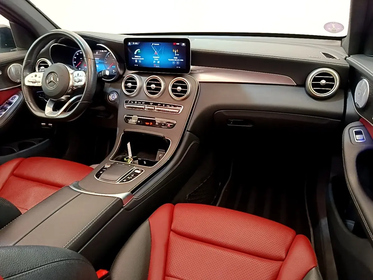 Vue intérieure avant du Mercedes GLC 300 e AMG Line 2020 avec sièges rouges et tableau de bord noir moderne.