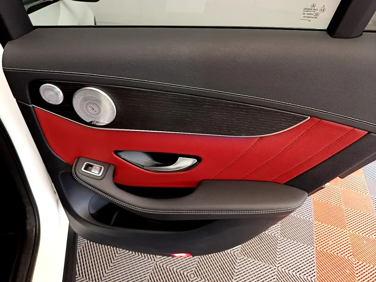 Vue rapprochée de la porte arrière gauche du Mercedes GLC Coupé blanc avec garniture cuir rouge et haut-parleur argenté.