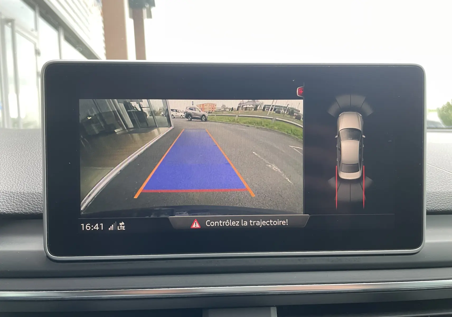 Écran intérieur de l'Audi S4 bleu Navarre montrant la caméra de recul avec trajectoire en bleu et vue 360° du véhicule.
