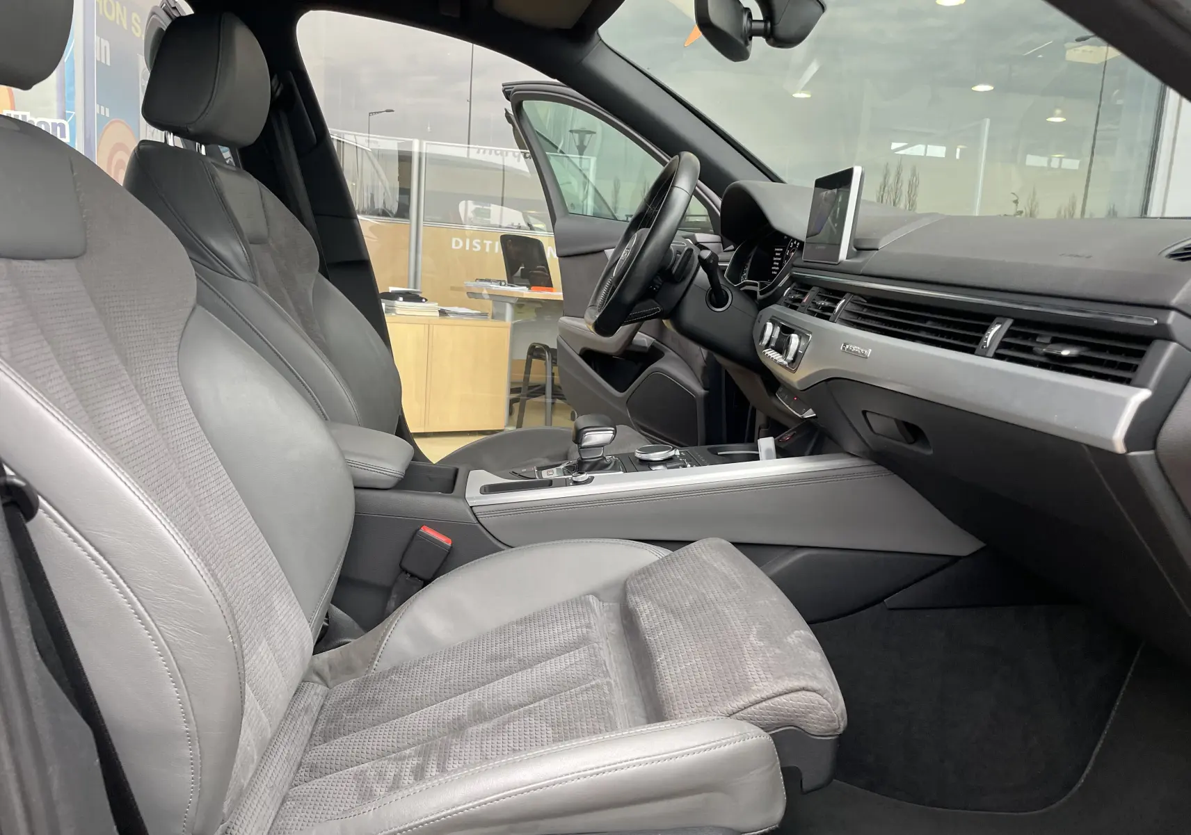 Vue intérieure côté conducteur de l'Audi S4 2016 avec sièges en cuir gris et tableau de bord moderne.