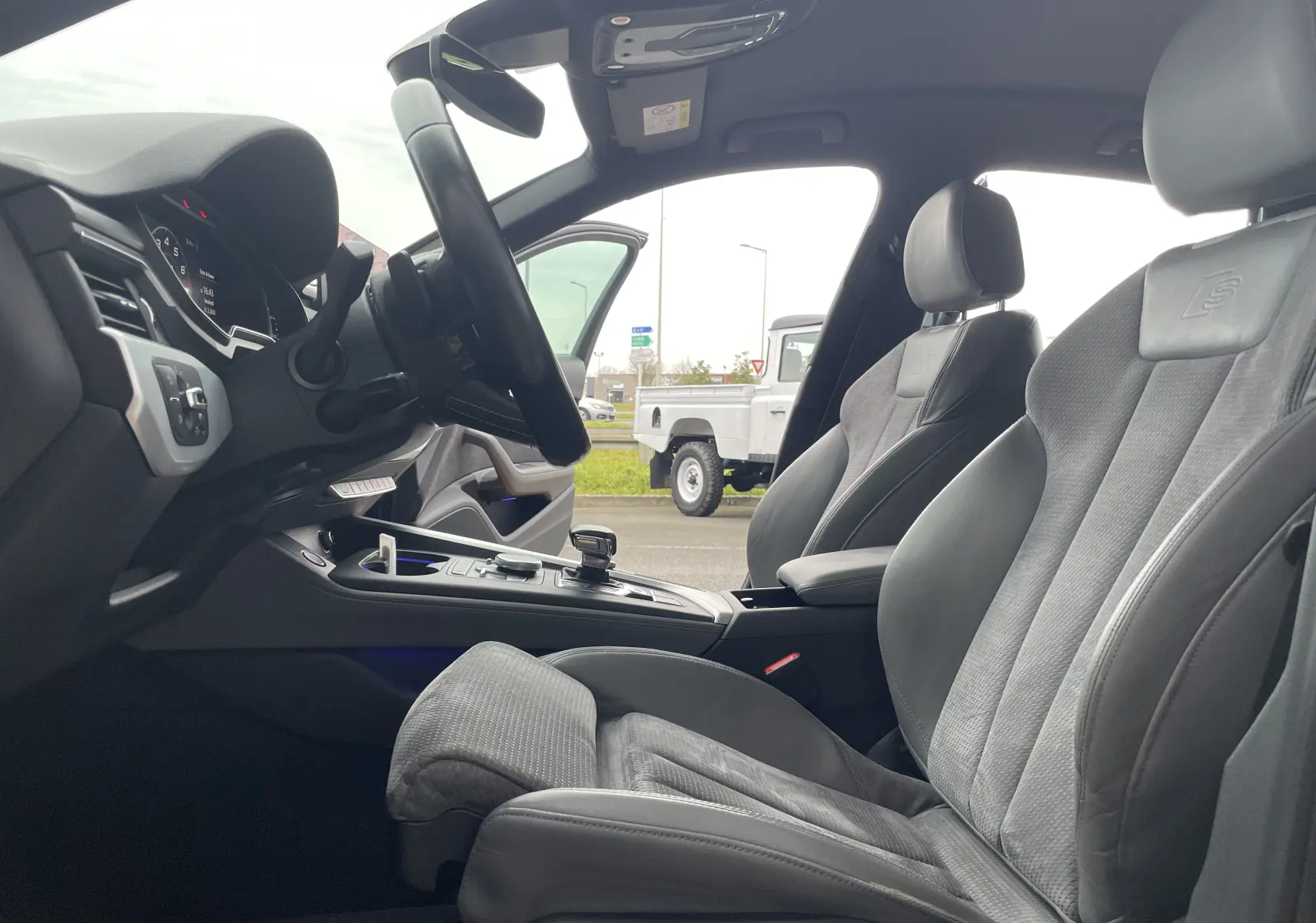 Vue intérieure côté conducteur de l'Audi S4 2016, sièges sport en cuir gris avec logo S embossé.