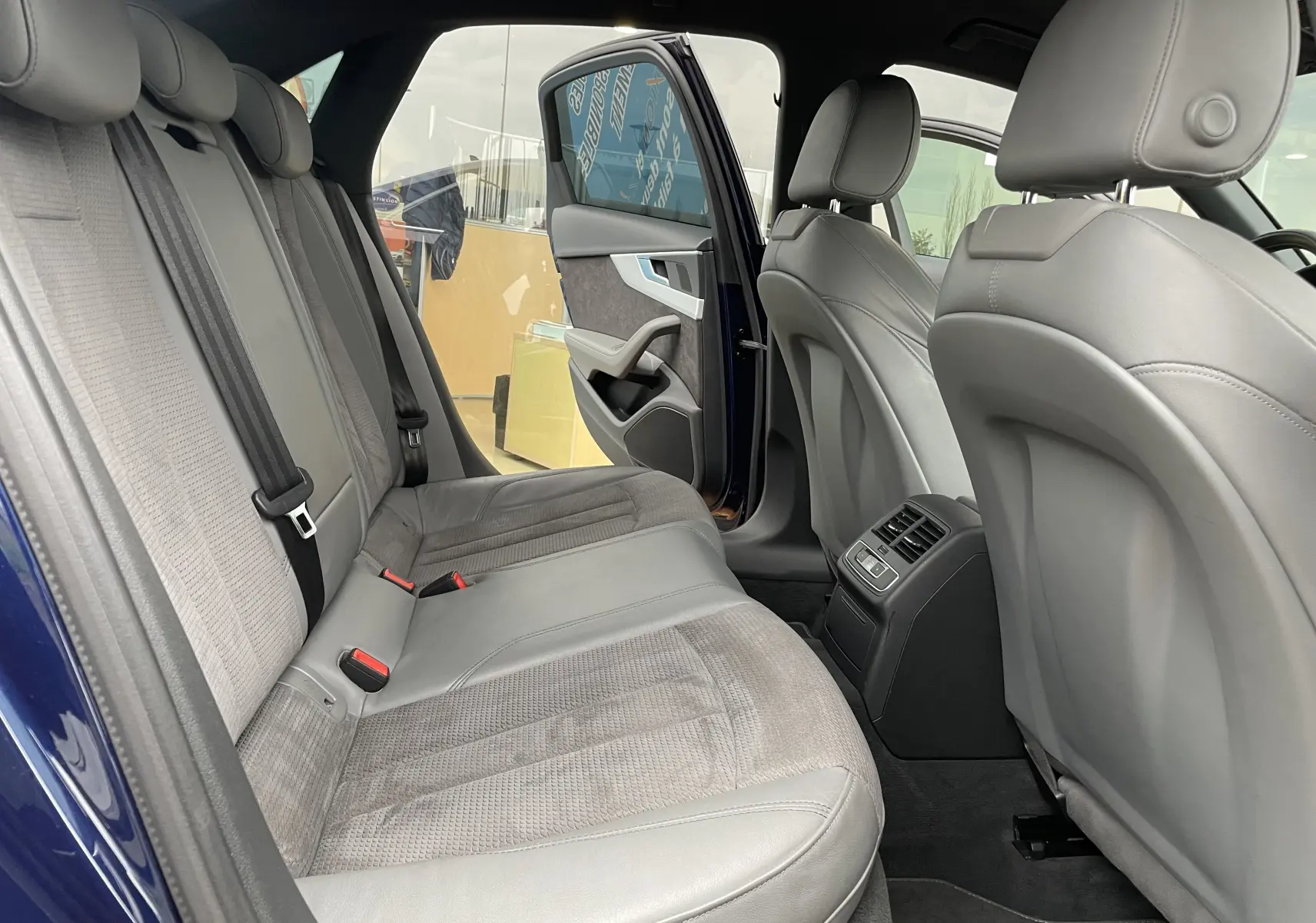 Vue intérieure arrière de l'Audi S4 2016 bleu Navarre, montrant les sièges gris en cuir et tissu avec porte arrière ouverte.