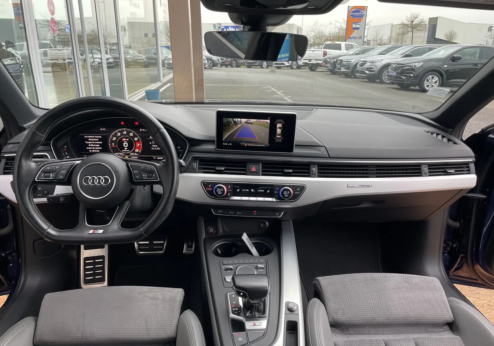 Vue intérieure frontale de l'Audi S4 3.0 V6 TFSI 2016 avec tableau de bord moderne et écran de caméra de recul allumé.