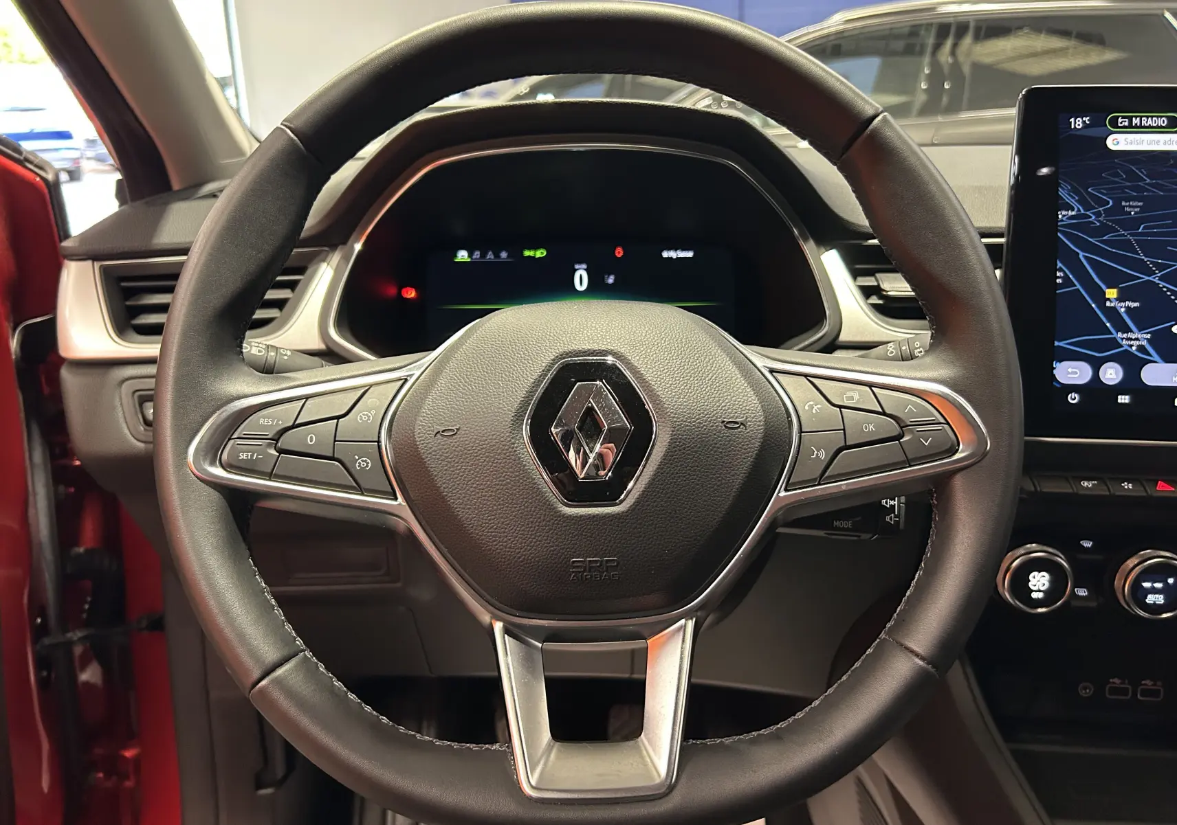 Vue centrée sur le volant du Renault Captur TCE 90CH TECHNO 2024, intérieur noir avec tableau de bord digital et écran tactile.