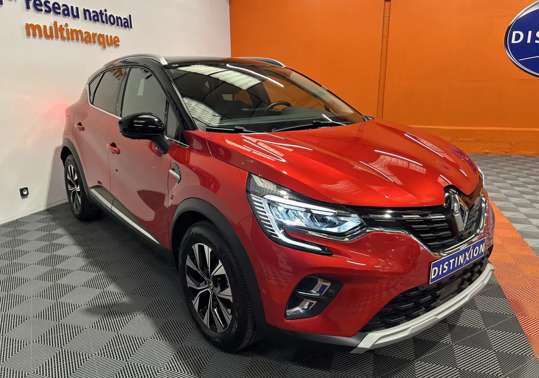 Renault Captur TCe 90ch Techno rouge flamme métal vu en 3/4 avant droit avec calandre et feux LED distinctifs.