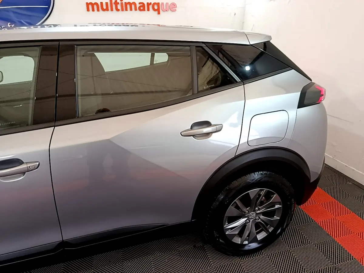 Vue latérale côté droit du Peugeot 2008 gris clair, mettant en valeur la porte arrière et la roue arrière.