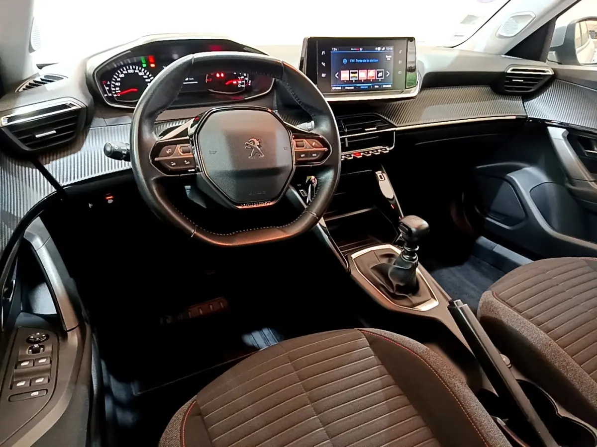 Vue intérieure avant de la Peugeot 2008 2020, volant cuir, tableau de bord avec écran tactile et levier de vitesse manuel.