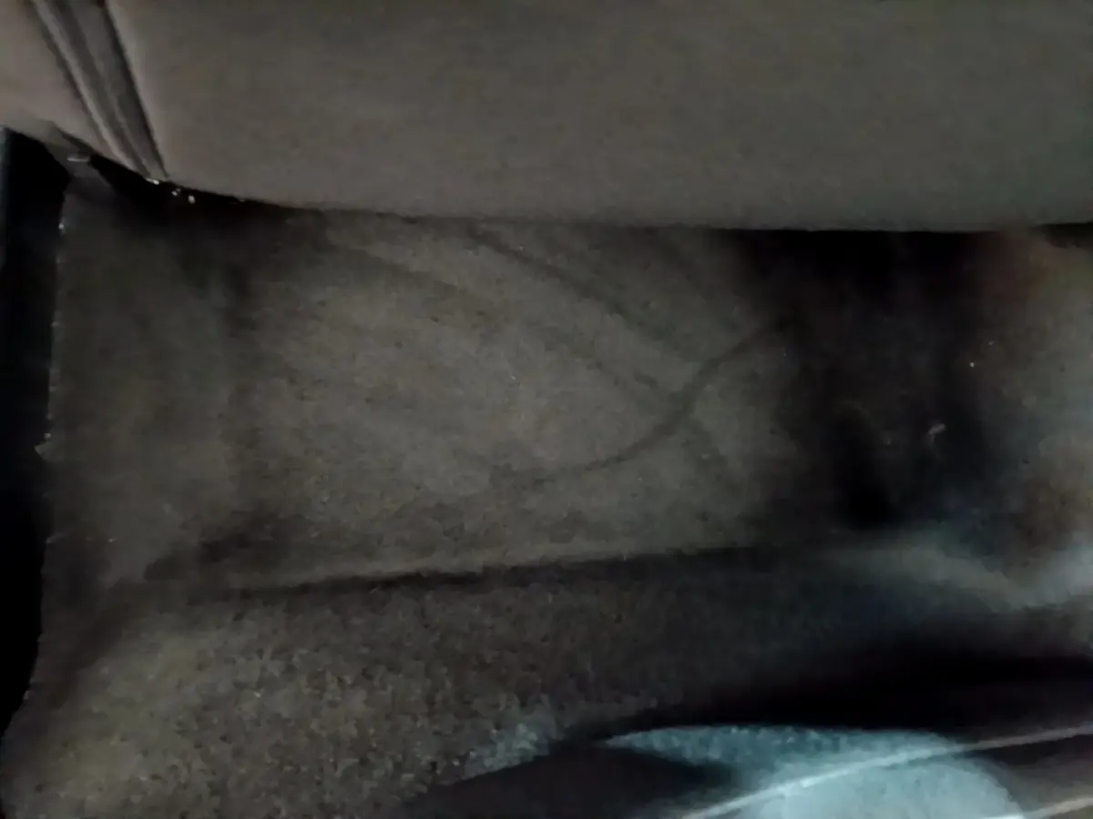 Gros plan sur le tapis de sol noir sous le siège arrière d’un Peugeot 2008 gris clair de 2020.