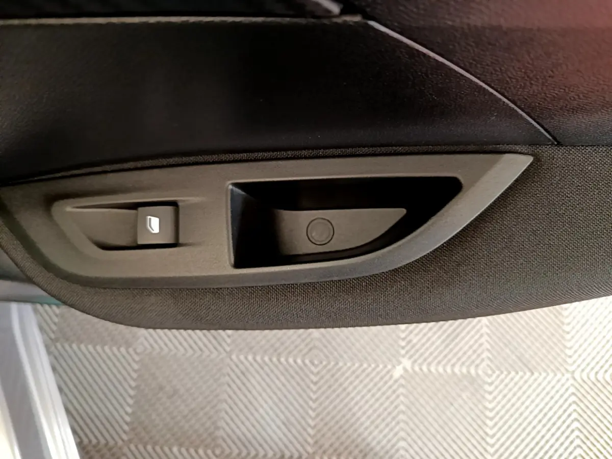 Gros plan sur la poignée intérieure noire de la porte côté conducteur du Peugeot 2008 gris clair 2020.