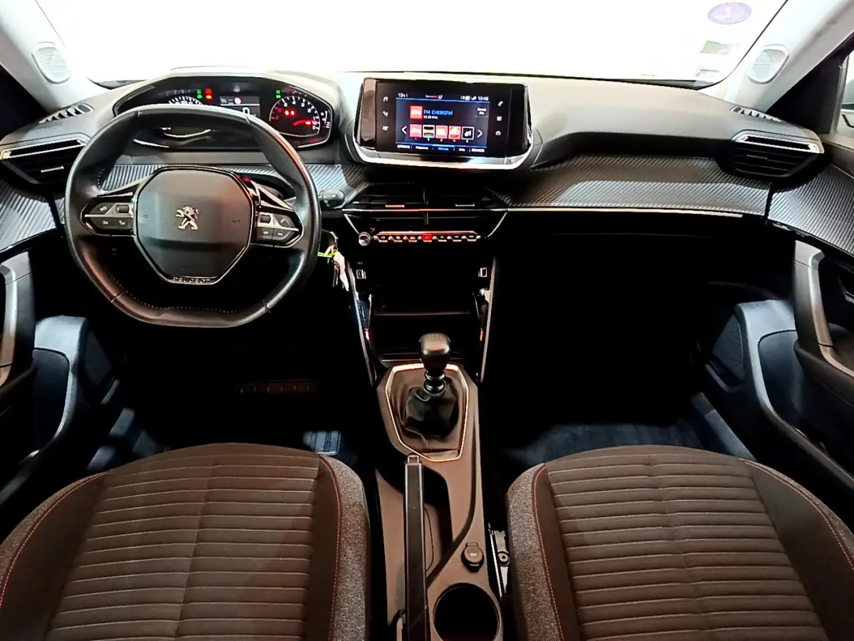 Intérieur Peugeot 2008 2020 vu de face, tableau de bord noir avec écran tactile et volant cuir multifonctions.
