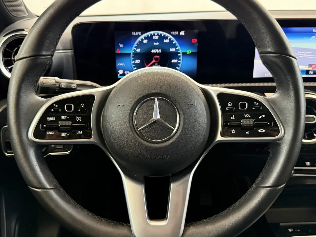 Vue rapprochée du volant cuir multifonctions d’une Mercedes Classe A 180 d Business Line avec tableau de bord digital.