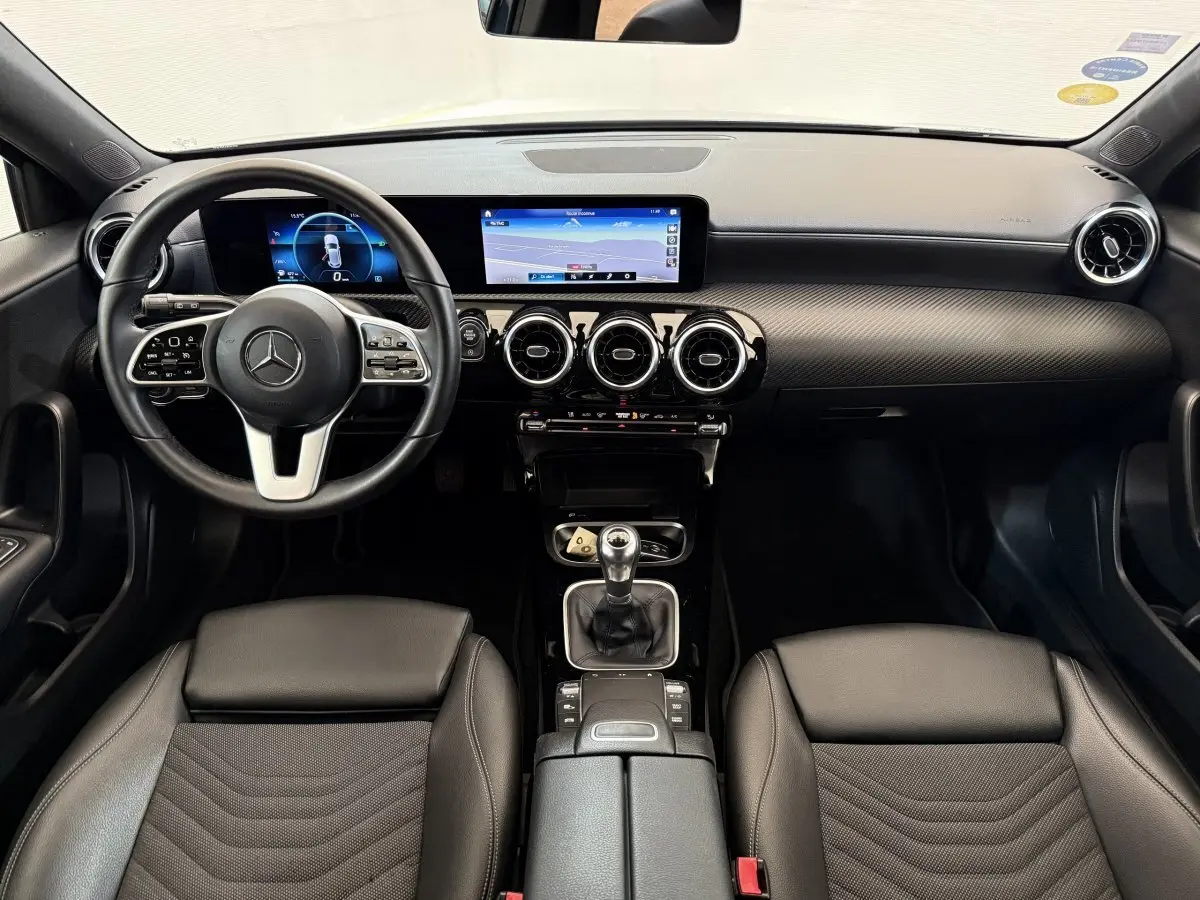 Intérieur noir de la Mercedes Classe A 180 d Business Line 2021, vue de face sur le tableau de bord et la boîte manuelle.