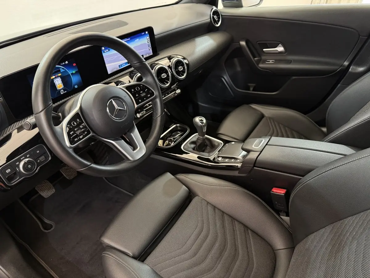 Vue intérieure côté conducteur de la Mercedes Classe A 180 d Business Line 2021 avec tableau de bord numérique et sellerie noire.