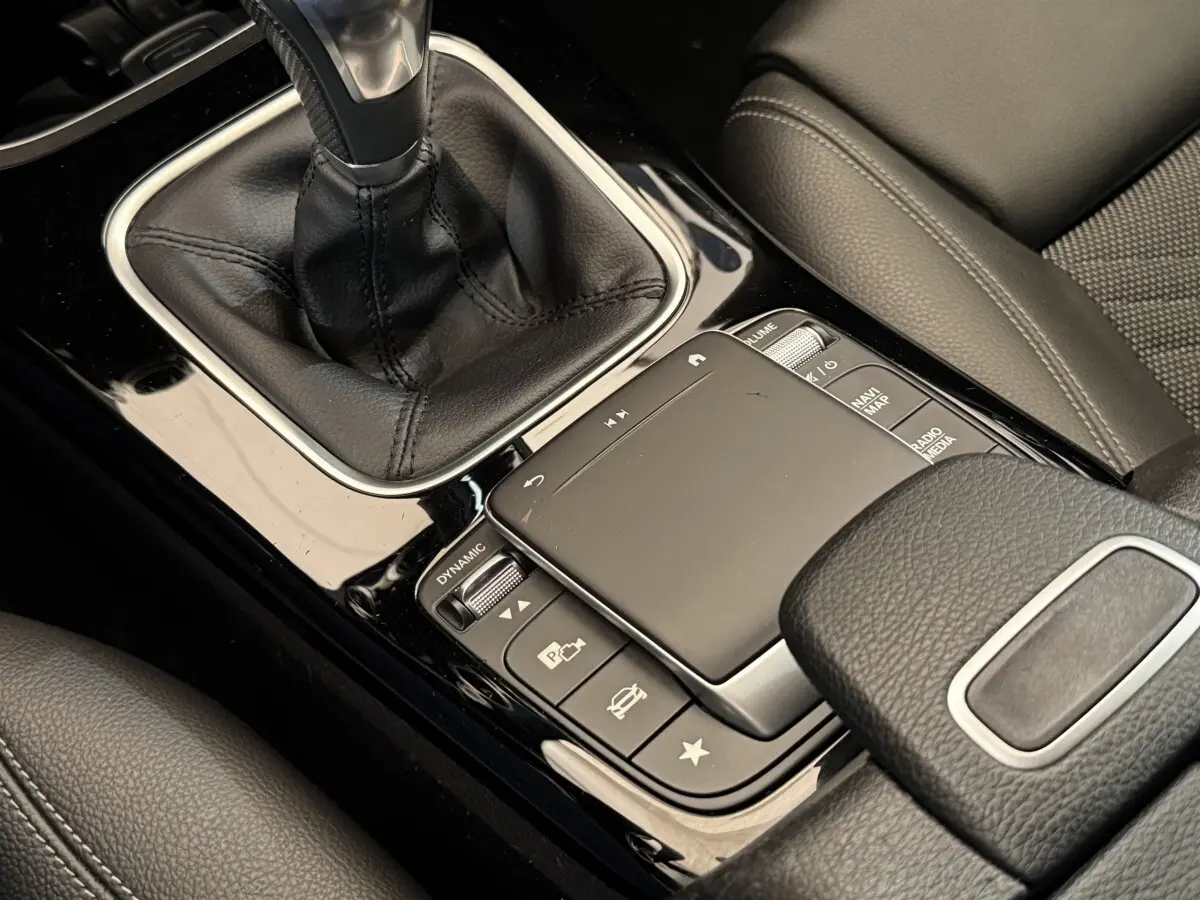 Gros plan sur la console centrale noire et le levier de vitesse cuir de la Mercedes Classe A 180 d Business Line 2021.