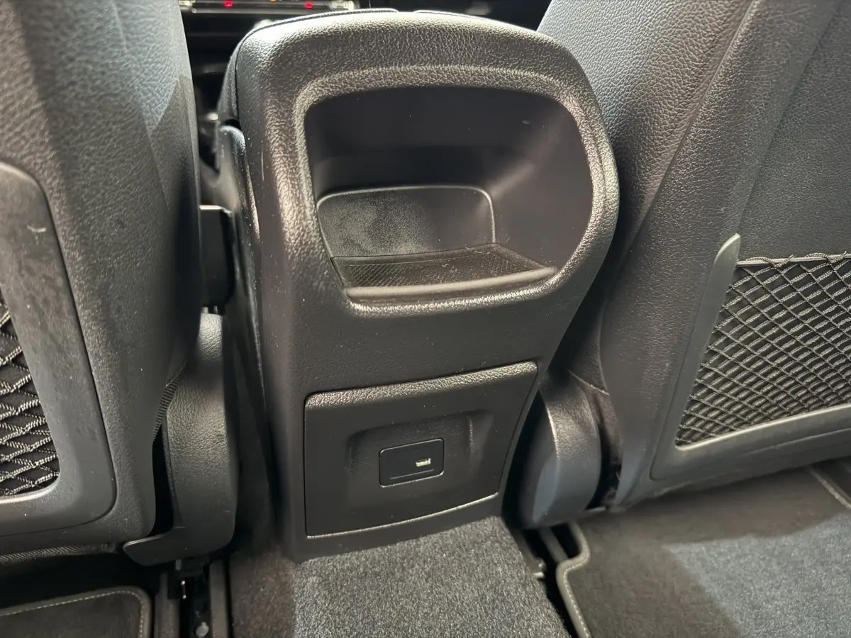 Prise USB arrière noire vue de près entre les sièges avant d’une Mercedes Classe A 180 d Business Line bleu.