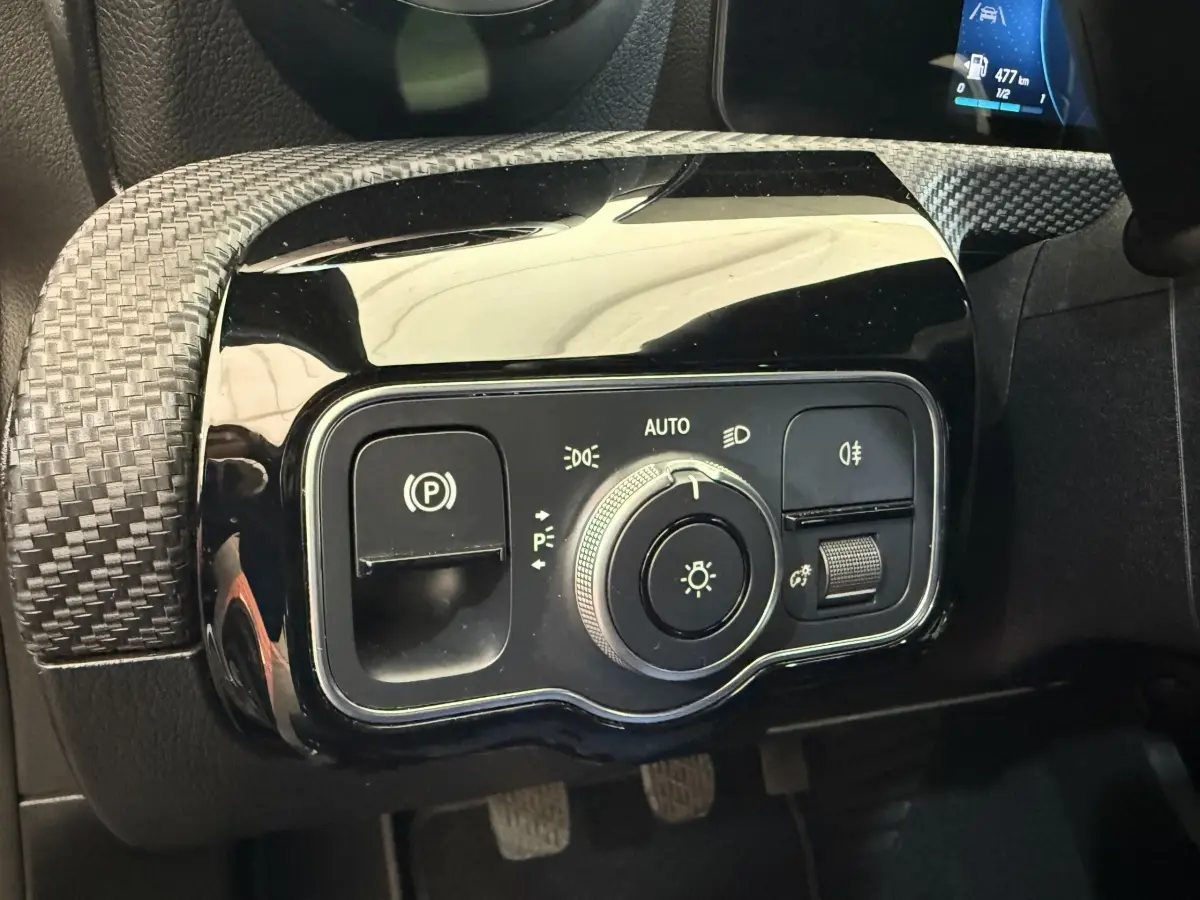Gros plan sur le panneau de commande des phares et du frein à main électrique dans une Mercedes Classe A 180 d Business Line 2021.
