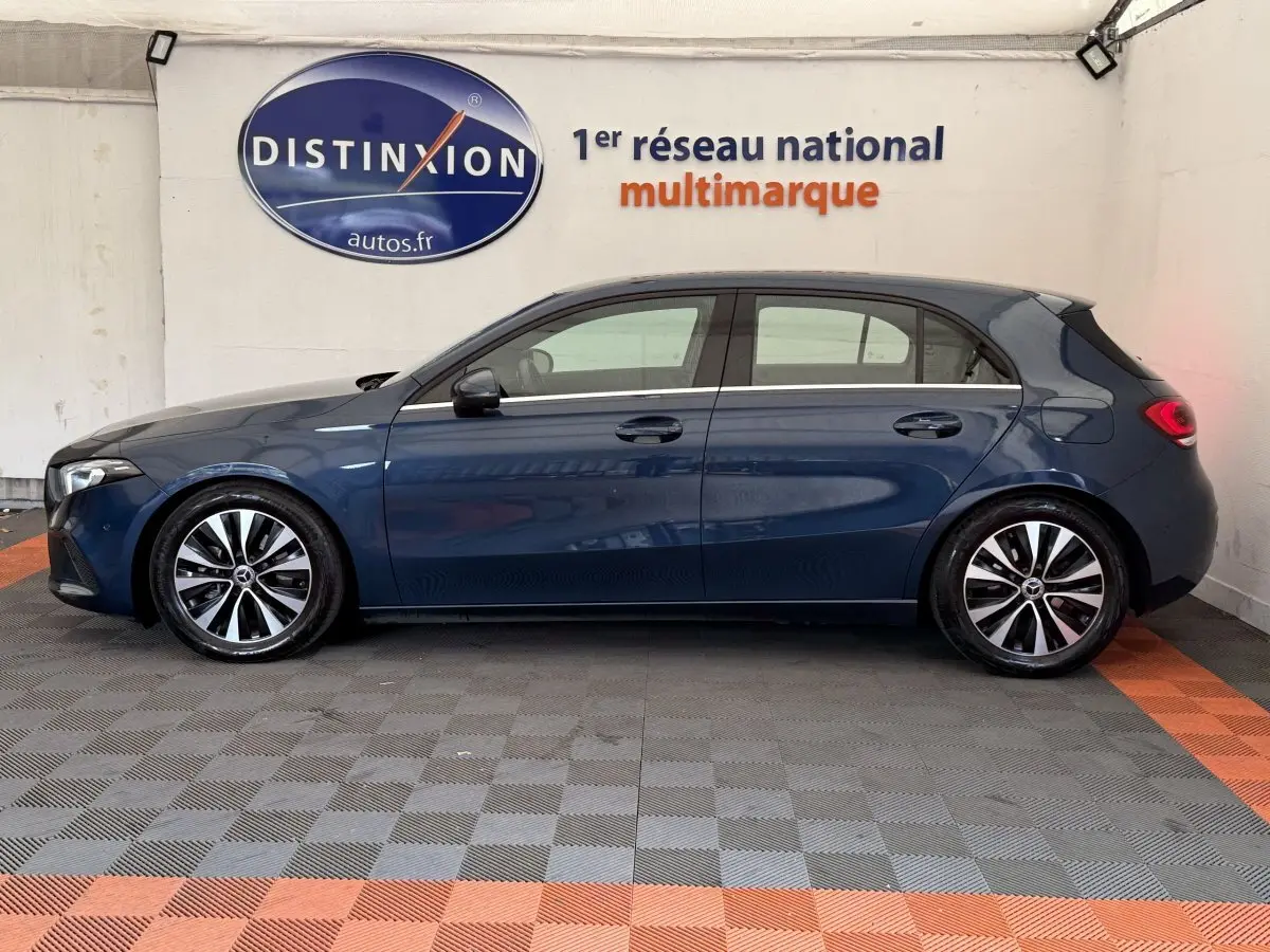 Vue de profil côté gauche d'une Mercedes Classe A 180 d Business Line bleu foncé, avec jantes alliage distinctives.