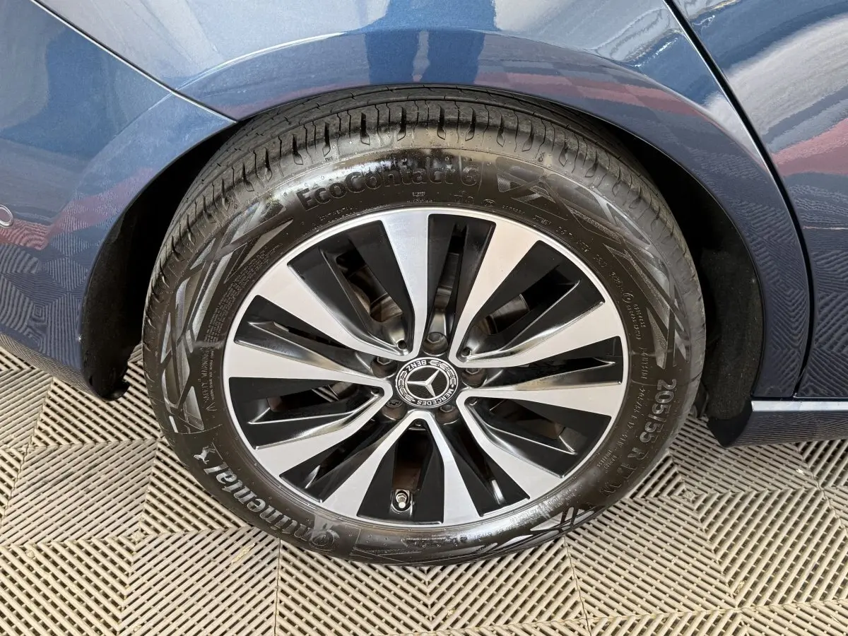Gros plan sur la roue arrière droite d’une Mercedes Classe A bleu 2021 avec jante alliage bicolore et pneu Continental.