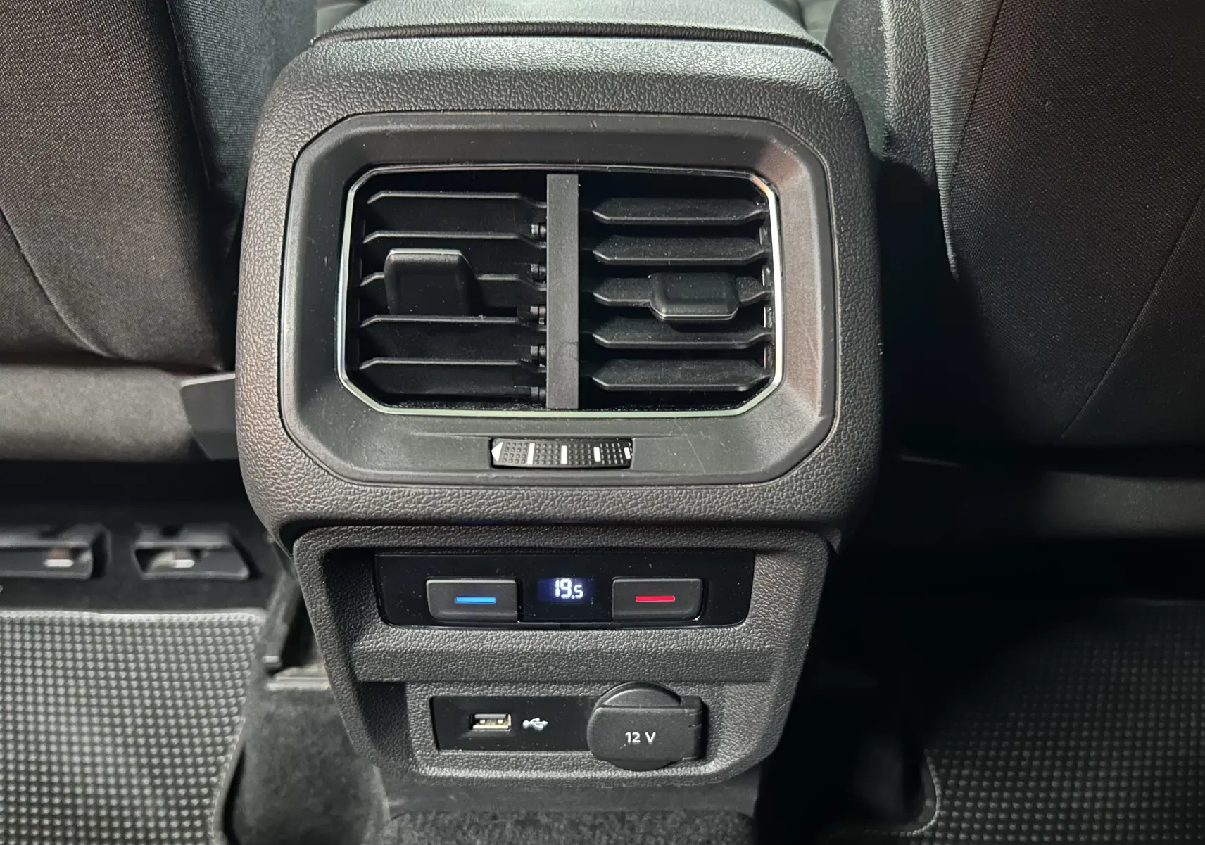 Vue rapprochée de la console arrière noire du Volkswagen Tiguan Allspace 2018 avec ventilation, réglage de température et prises USB et 12V.