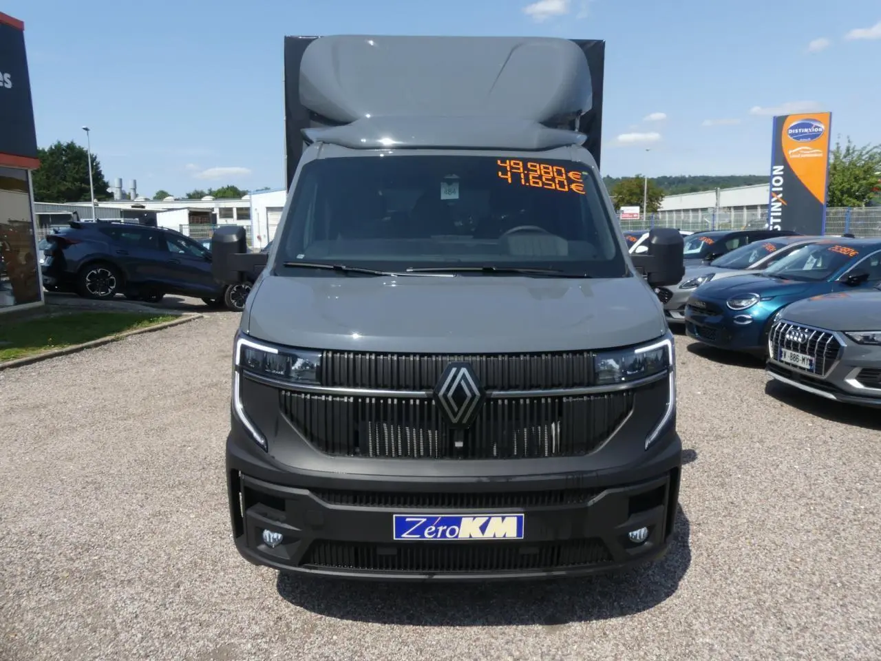 Vue avant d'un Renault Master Extra gris avec calandre noire et prix affiché sur le pare-brise.