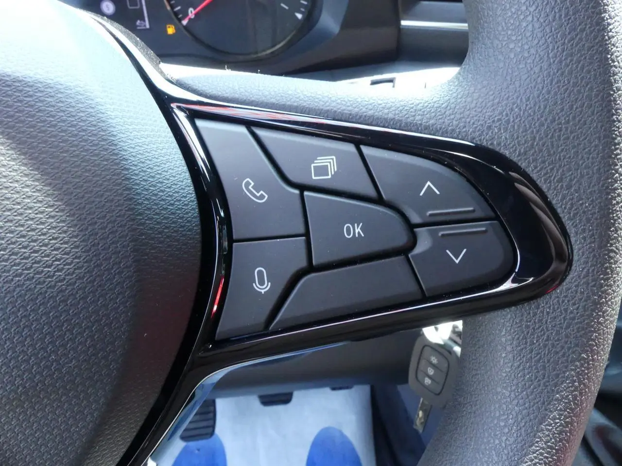 Gros plan sur les commandes multifonctions noires du volant du Renault Master Extra 2025, finition tissu gris.