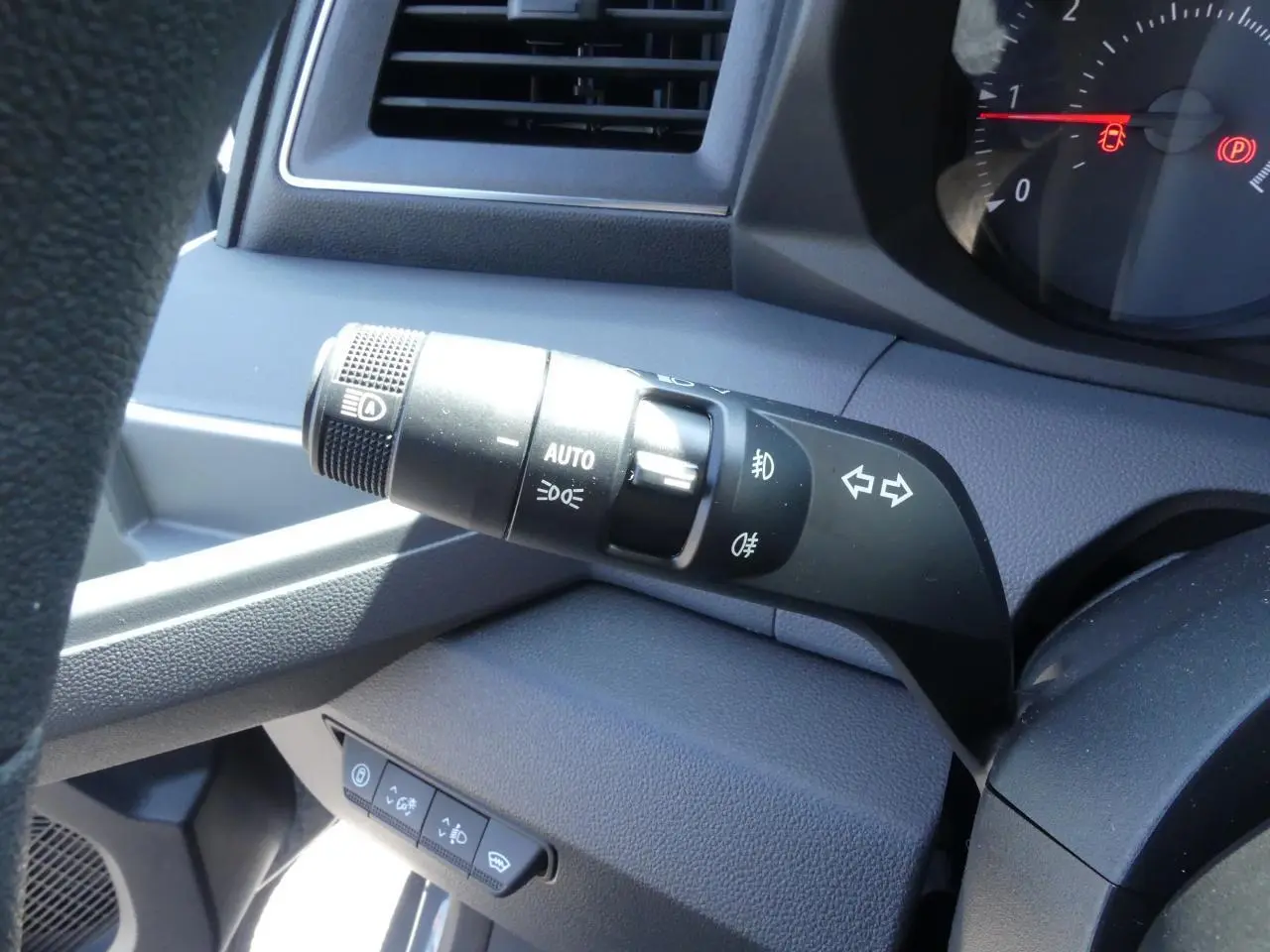 Gros plan sur la commande des feux et clignotants côté gauche du tableau de bord gris du Renault Master 2025.