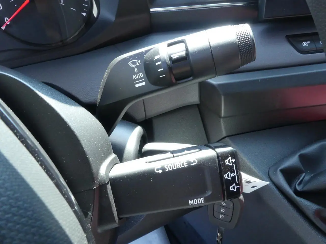 Gros plan sur les commandes au volant du Renault Master gris, montrant les boutons source et mode côté conducteur.