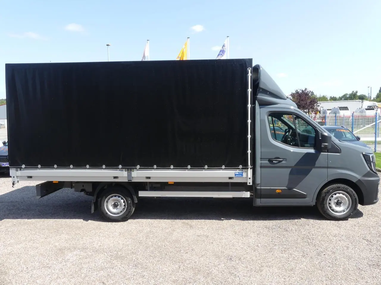 Renault Master Extra gris vu de profil côté droit avec bâche noire couvrant la zone de chargement.