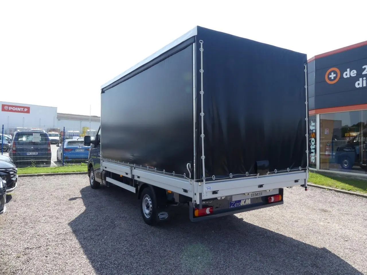 Renault Master Extra gris vu en 3/4 arrière droit avec bâche noire et jantes tôles 16 pouces.