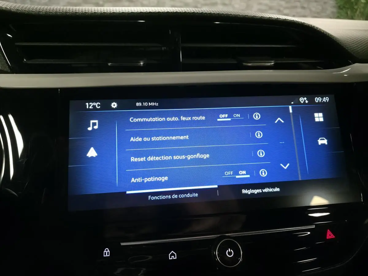 Écran tactile central de l’Opel Corsa noir 2024 affichant les réglages d’aide à la conduite et stationnement.