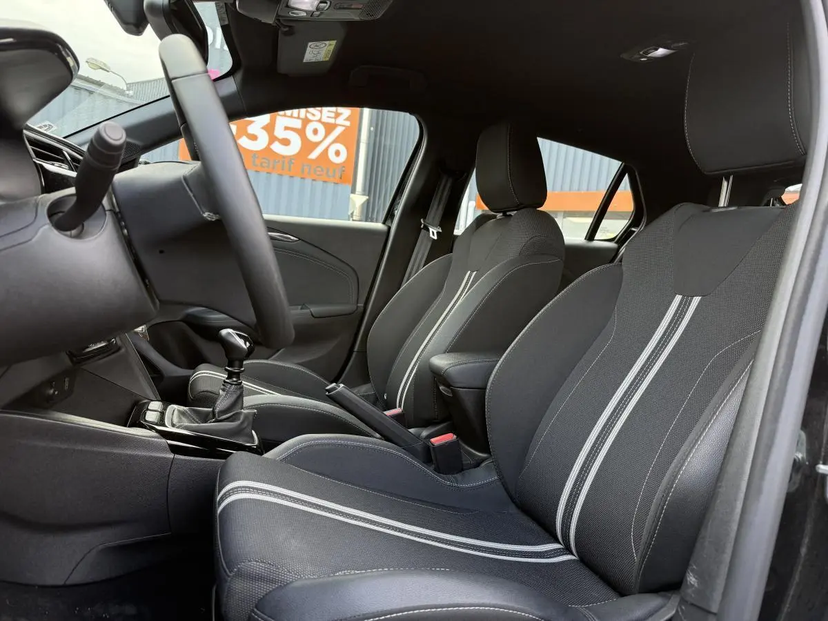 Intérieur noir de l'Opel Corsa 2024, vue côté droit sur sièges sport avec surpiqûres blanches et volant multifonction.