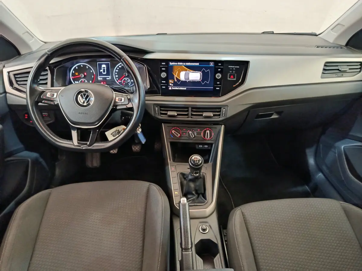 Intérieur Volkswagen Polo 2020 vue avant du tableau de bord avec volant cuir, écran tactile et levier de vitesse manuel.