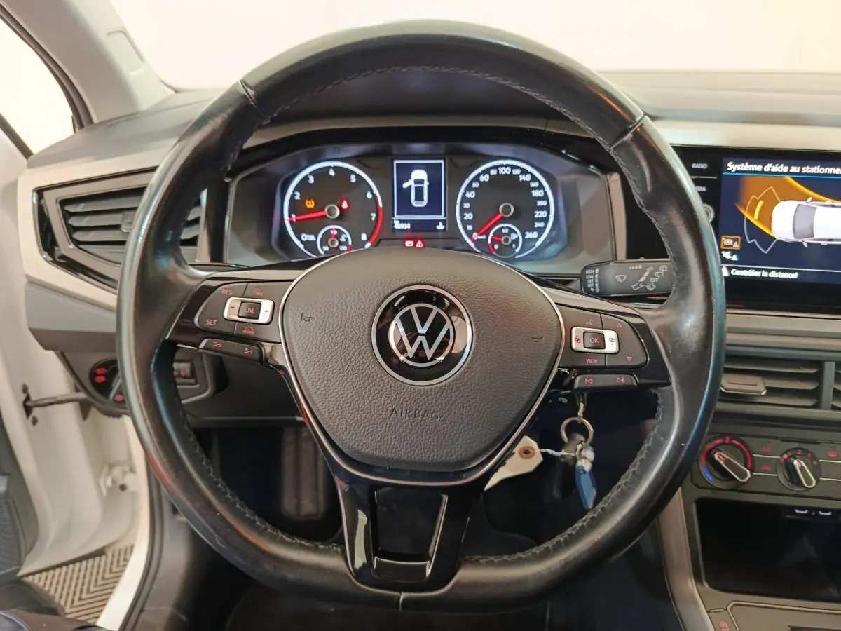 Vue rapprochée du volant cuir et alu Volkswagen Polo 2020 avec tableau de bord numérique et écran tactile latéral.