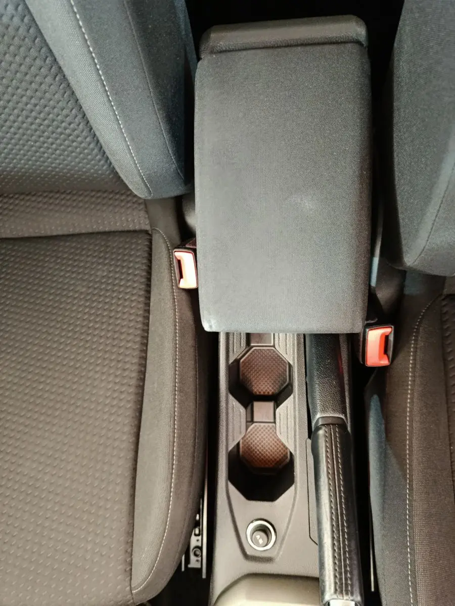 Vue plongeante sur la console centrale noire et les sièges tissu gris foncé de la Volkswagen Polo 1.0 TSI 95 Lounge Business blanche.