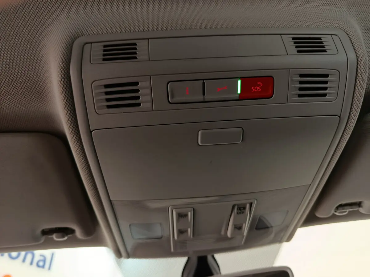 Plafonnier intérieur avec bouton SOS éclairé de la Volkswagen Polo blanche 2020, vue en contre-plongée depuis l'habitacle.
