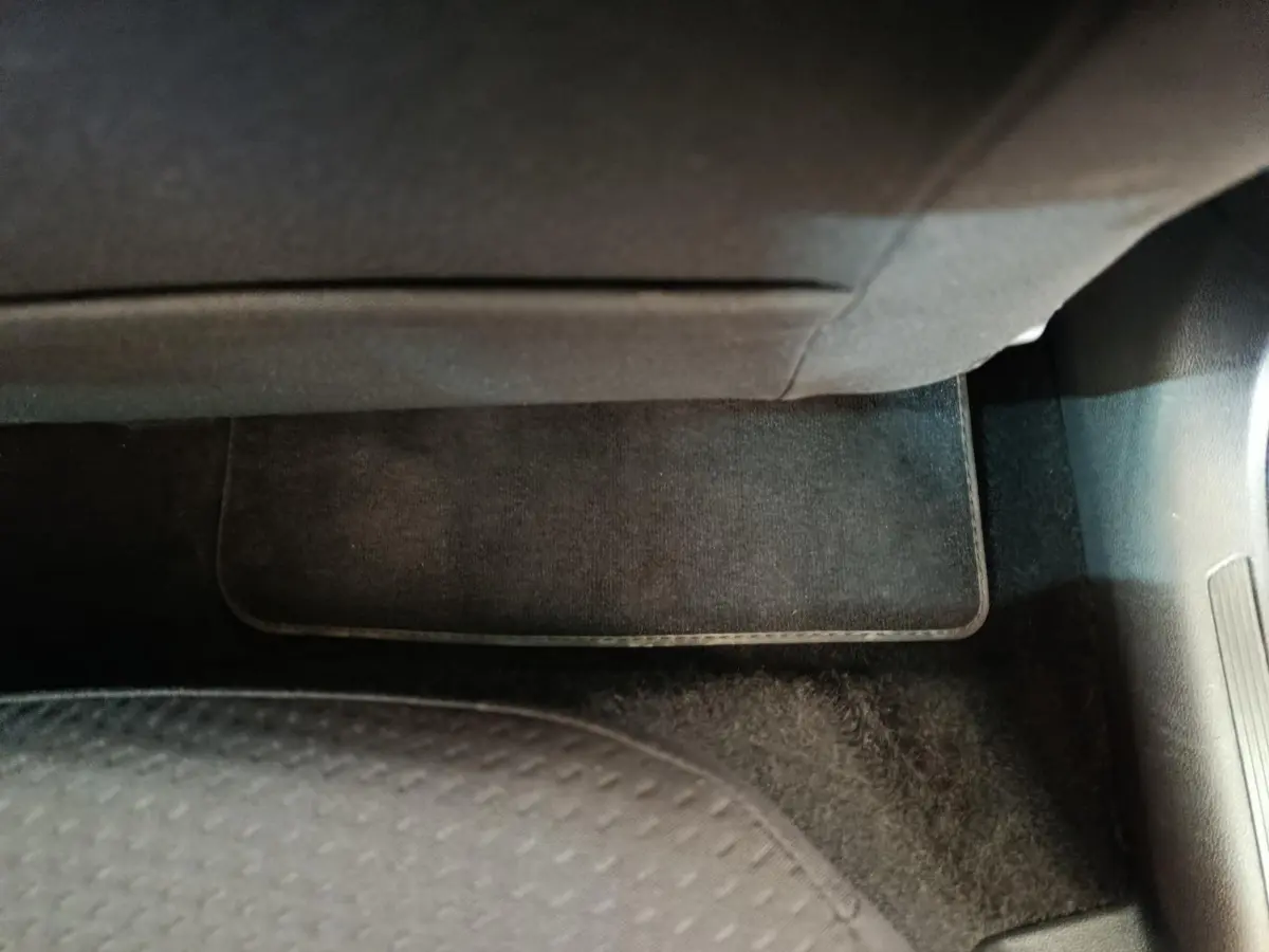 Gros plan sur le tapis de sol noir côté passager avant d'une Volkswagen Polo blanche 2020.