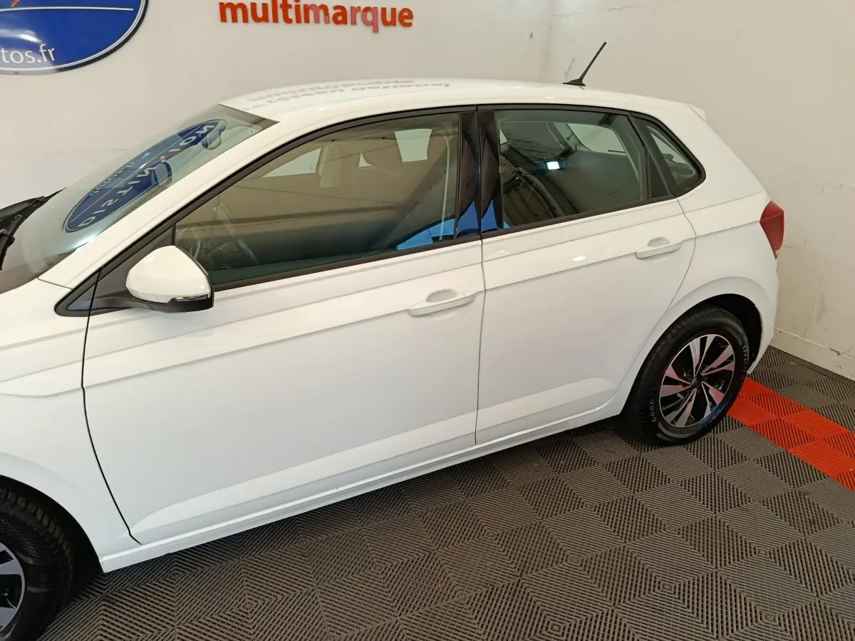 Profil côté gauche d'une Volkswagen Polo blanche 2020, avec jantes alliage et rétroviseurs blancs.