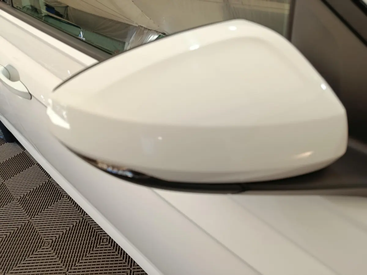 Gros plan sur le rétroviseur droit blanc d'une Volkswagen Polo 2020, avec clignotant intégré visible.