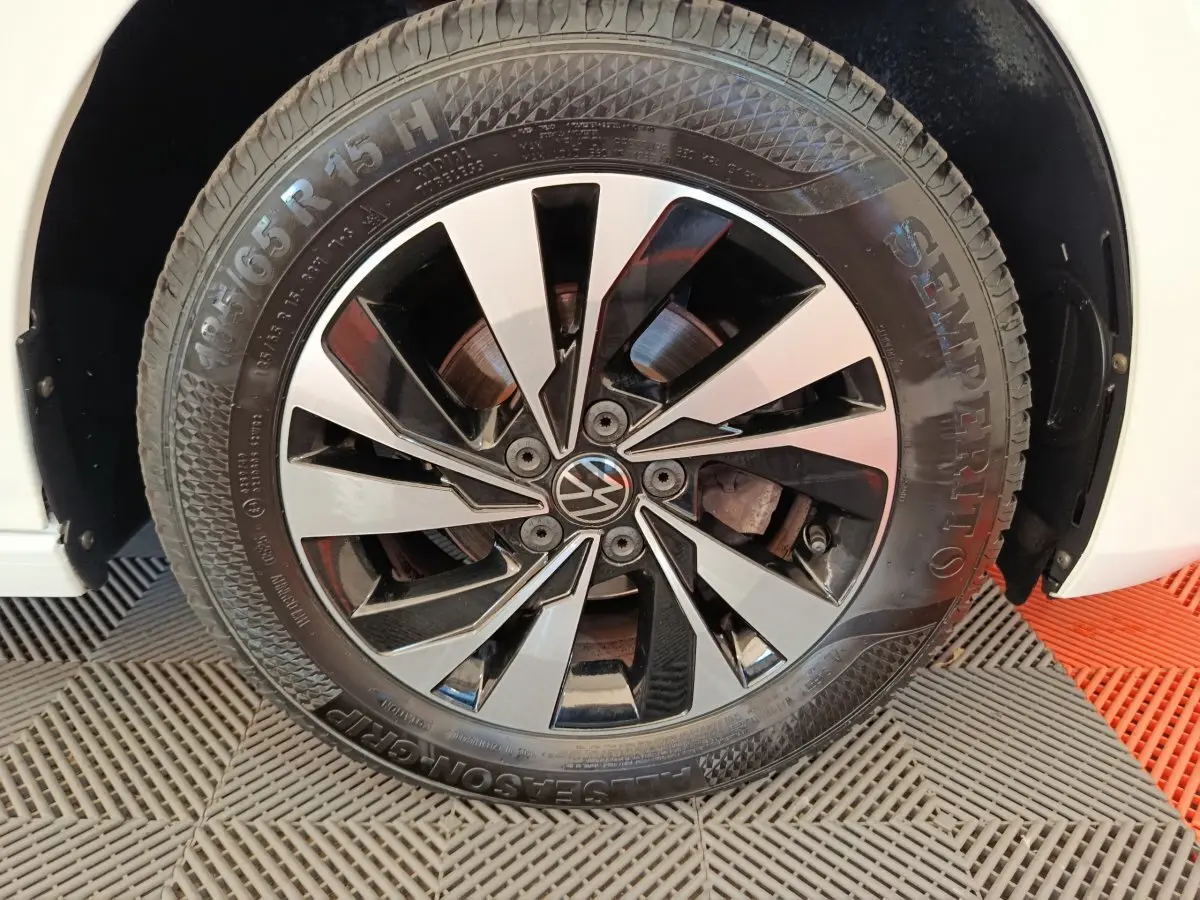 Gros plan sur la roue avant droite d'une Volkswagen Polo blanche, avec jante alliage noir et argentée design moderne.