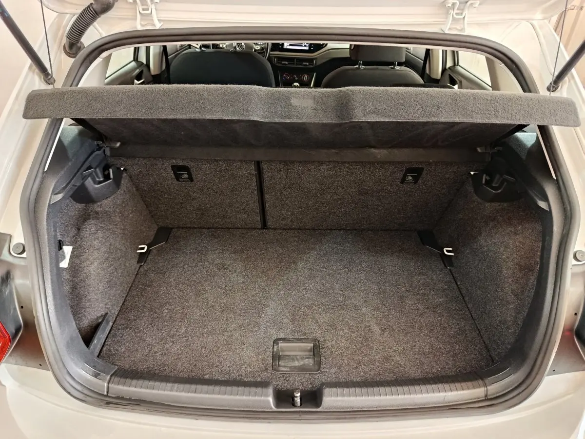 Coffre ouvert vu de l'arrière d'une Volkswagen Polo blanche 2020, montrant l'espace de chargement et la tablette cache-bagages.