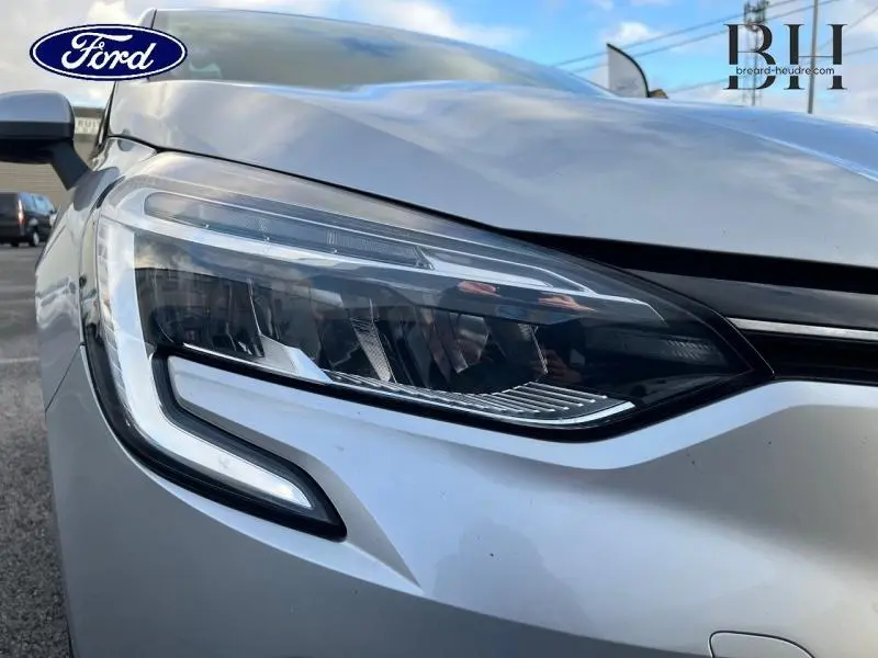 Gros plan sur le phare avant gauche d'une Renault Clio gris platine 2019, soulignant son design moderne et LED.
