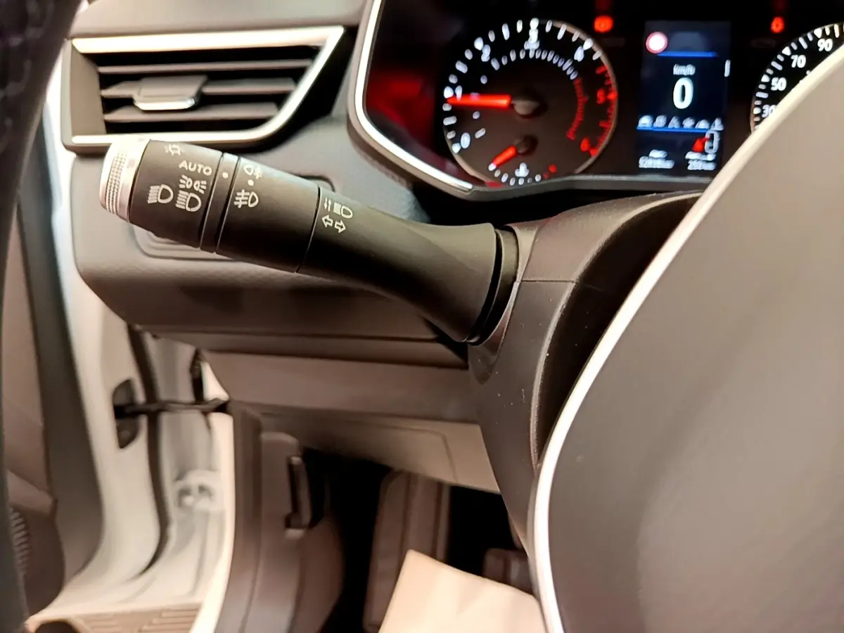 Gros plan sur le commodo gauche et le tableau de bord numérique de la Renault Clio Business Blue dCi 85 blanche de 2020.