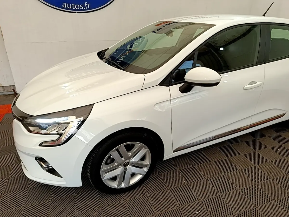 Vue 3/4 avant droite d'une Renault Clio Business Blue dCi 85 blanche avec jantes alliage et rétroviseurs blancs.