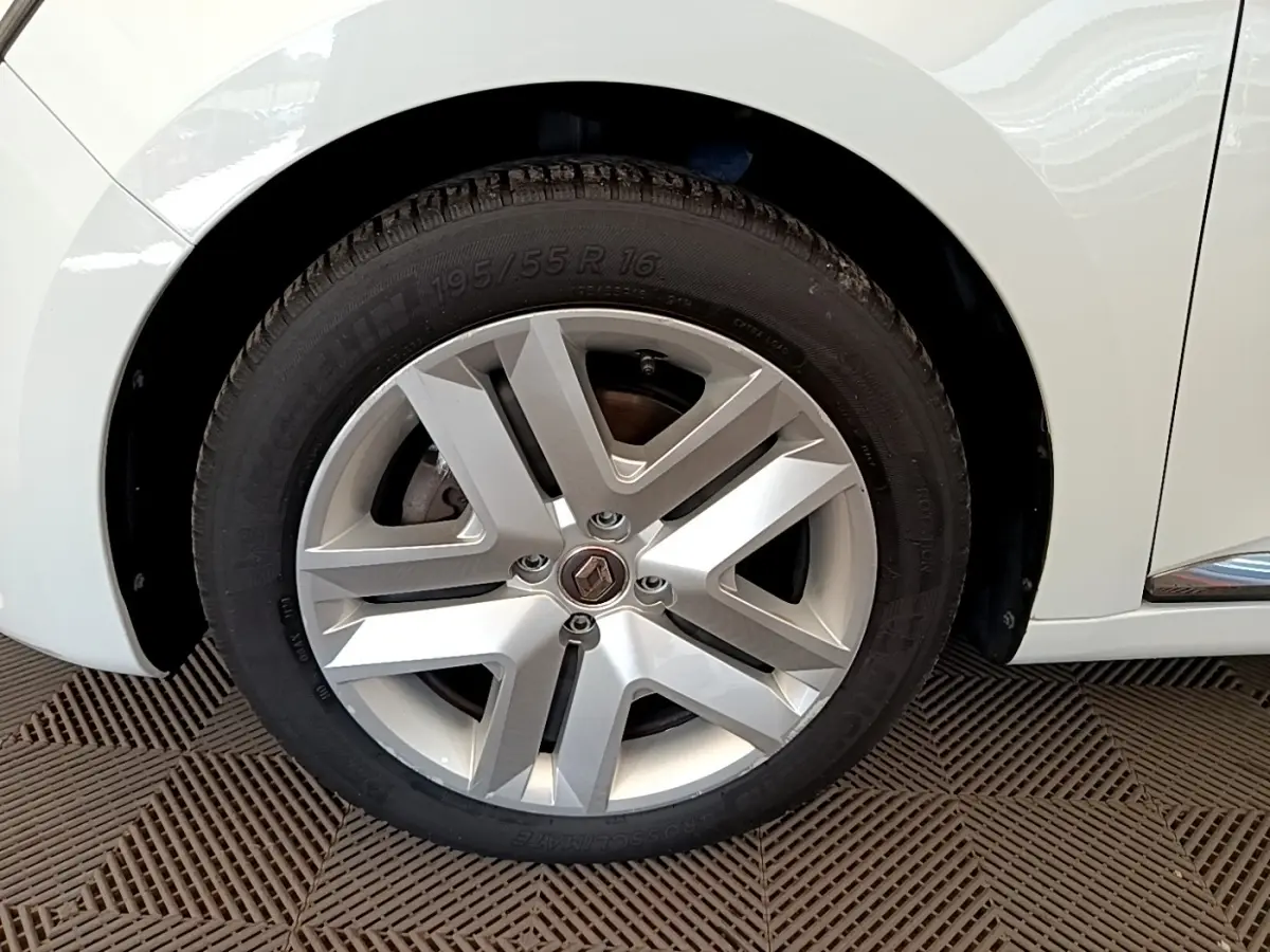 Gros plan sur la roue avant gauche blanche d’une Renault Clio Business Blue dCi 85 avec jante alliage moderne.
