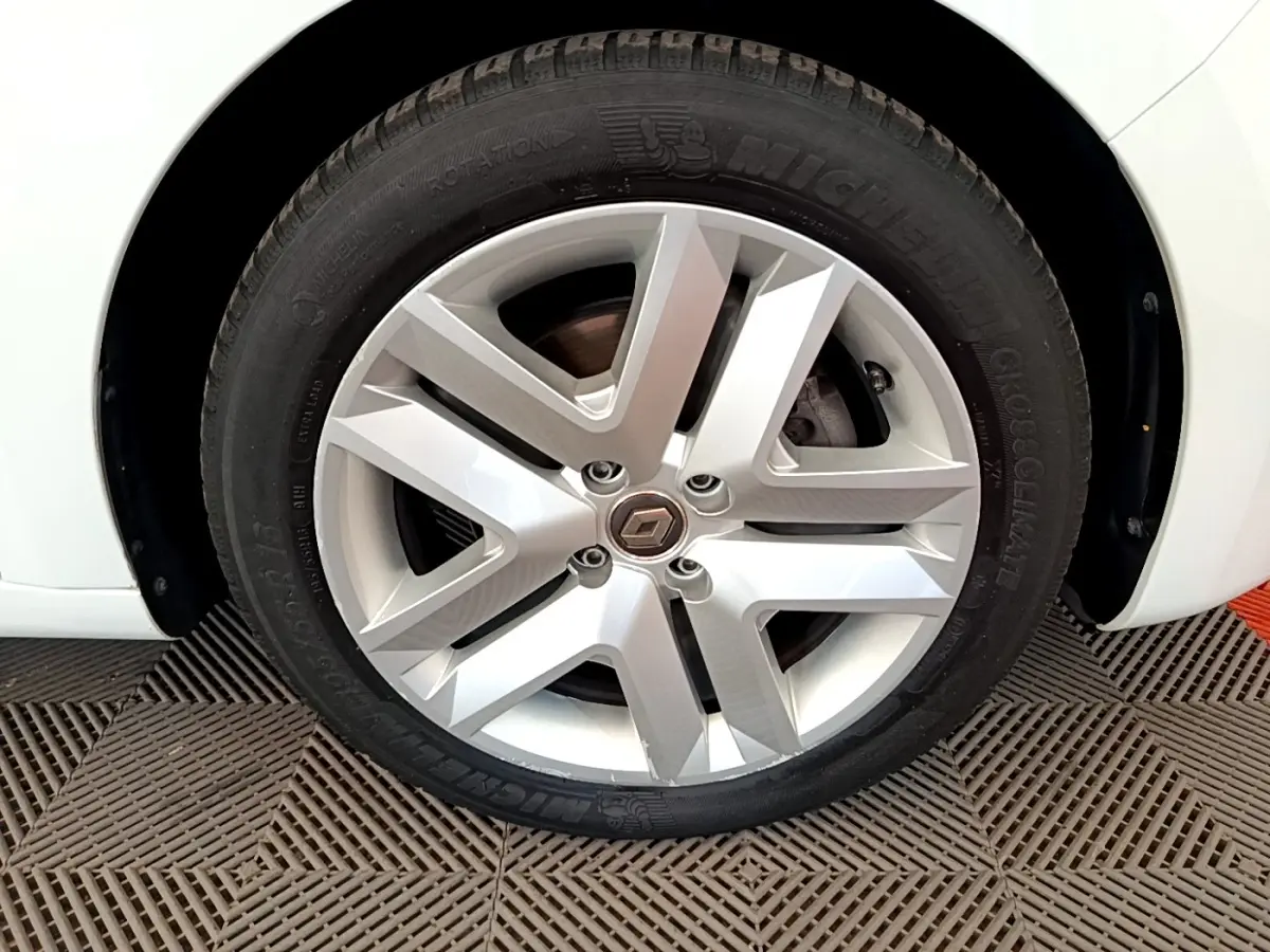 Gros plan sur la roue avant gauche blanche d'une Renault Clio Business Blue dCi 85, jante alliage et pneu Michelin.