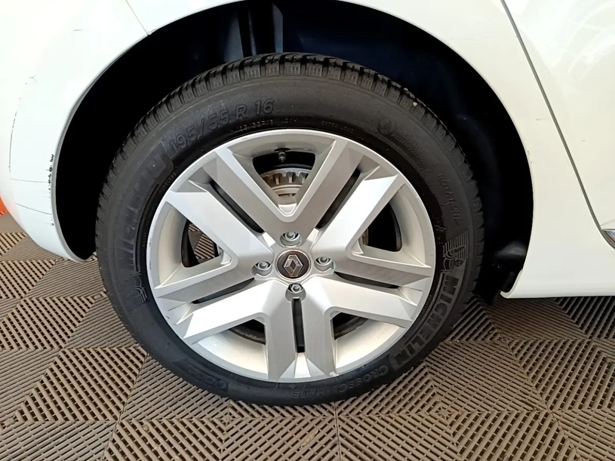 Gros plan sur la roue avant droite blanche d'une Renault Clio Business Blue dCi 85 avec jante alliage argentée.