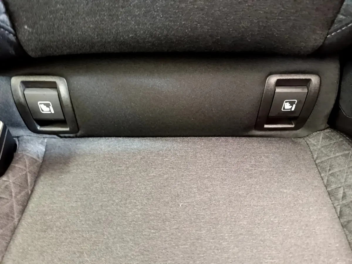 Détail des commandes de rabattement des sièges arrière en tissu gris dans une Renault Clio Business Blue dCi 85.